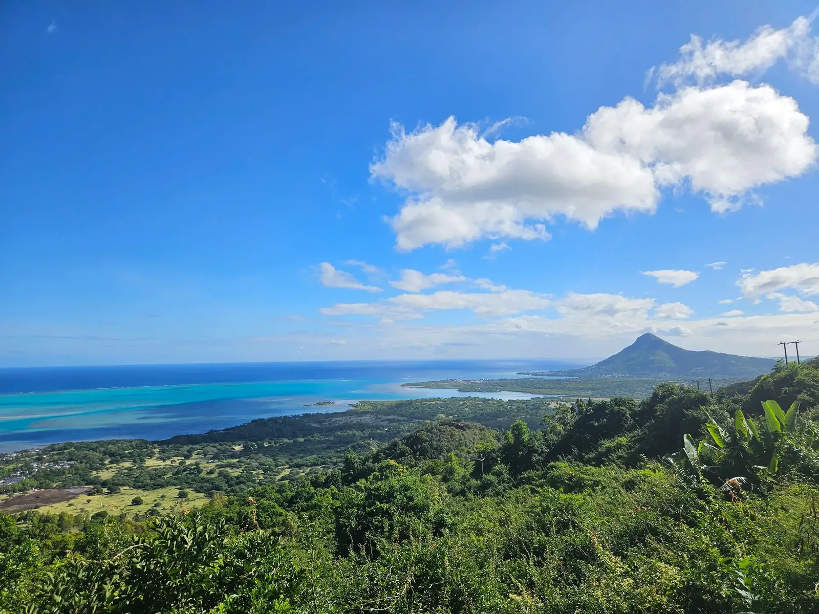 Lagon turquoise, collines boisées et paysage montagneux sur la côte sud-ouest de Maurice.